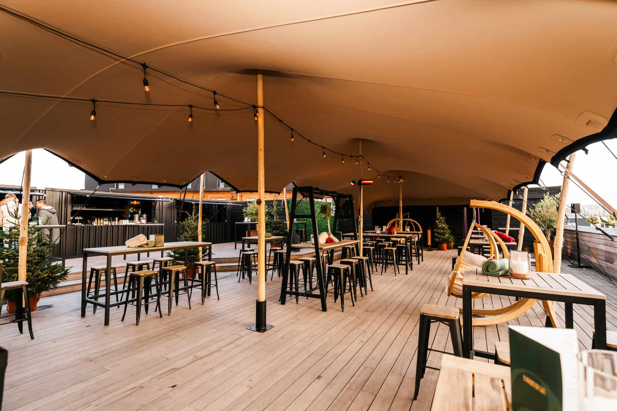 Gezellige buiten terras van Brisa Antwerp met comfortabele zitplaatsen, sfeervolle verlichting en een grote parasol voor schaduw, perfect voor ontspannen dineren of drinken.